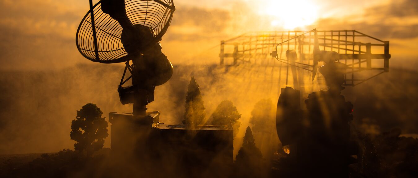 Silhouettes of satellite dishes or radio antennas against night sky. Space observatory or Air defence radar over dramatic sunset sky. Creative artwork decoration. Selective focus.