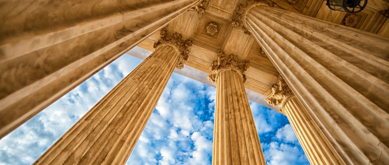 greek style columns against a blue sky