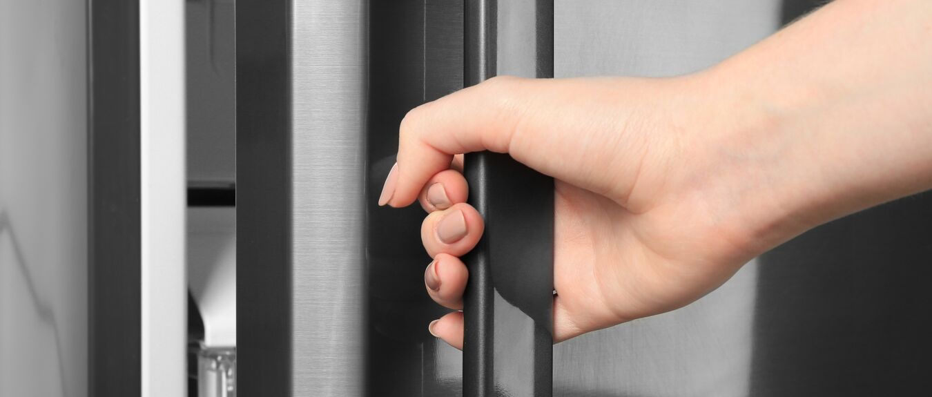 Woman opening refrigerator door, closeup